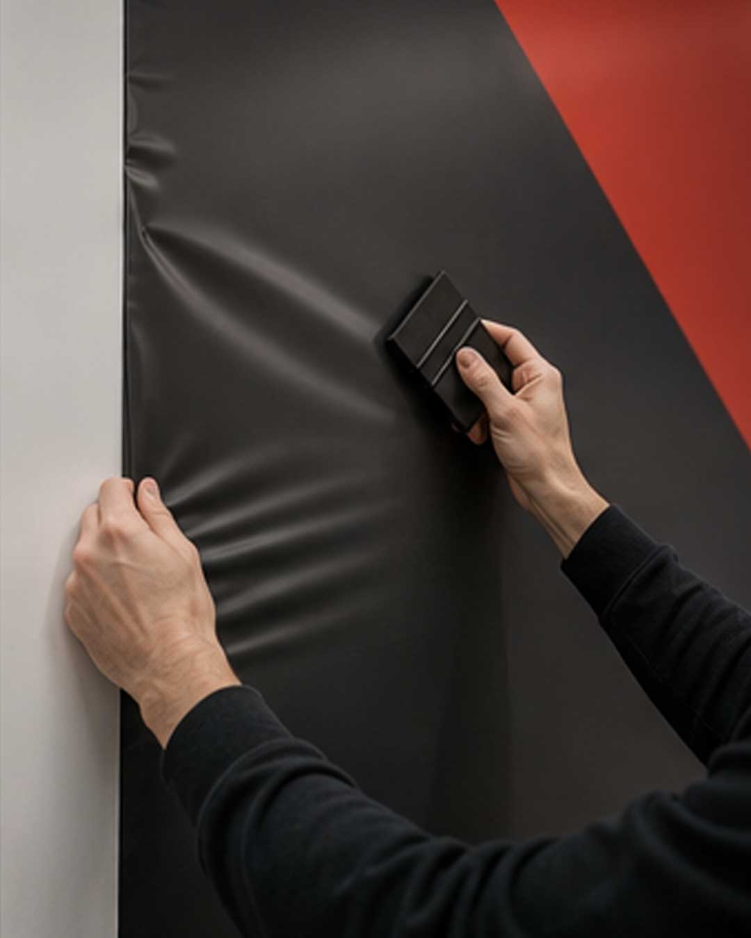 Applicazione di una grafica durante l’allestimento di uno stand fieristico